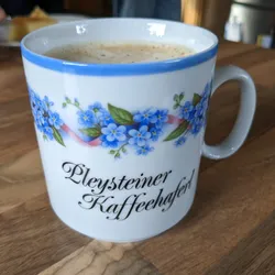 A cup with a floral pattern and the inscription "Pleysteiner Kaffeehaferl"