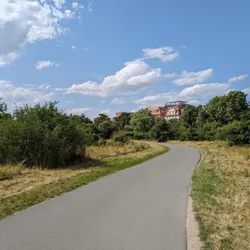 A paved road with a house in the background near Fuchsloch in Nuremberg