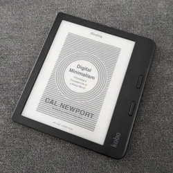 The eReader Kobo Libra 2 lying on the sofa with the book Digital Minimalism displayed on its screen