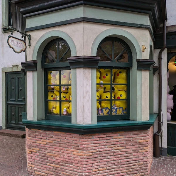 Many large Pikachu plush toys hanging behind two windows